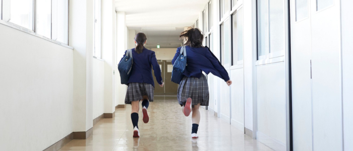 Two female students in school uniforms with dark hair running down a school hallway Interim Leadership in Independent Schools | Why you need an interim leader in your schools group | How interim leadership can benefit your independent schools group |