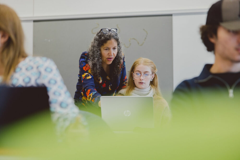 Female tutor interacting with students in class